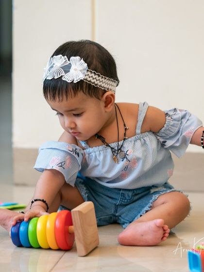 Capturing a baby at play. This candid shot shows her interacting with her toys, a natural and beautiful moment.