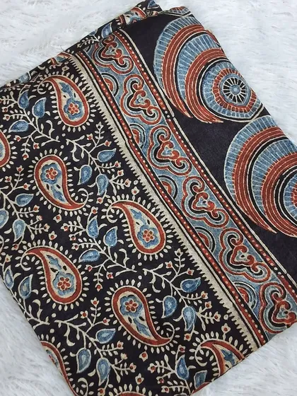 A stunning Ajrakh printed modal fabric with a classic paisley and circular motif design. The rich, dark colors make it a sophisticated choice for creating your own ethnic wear.