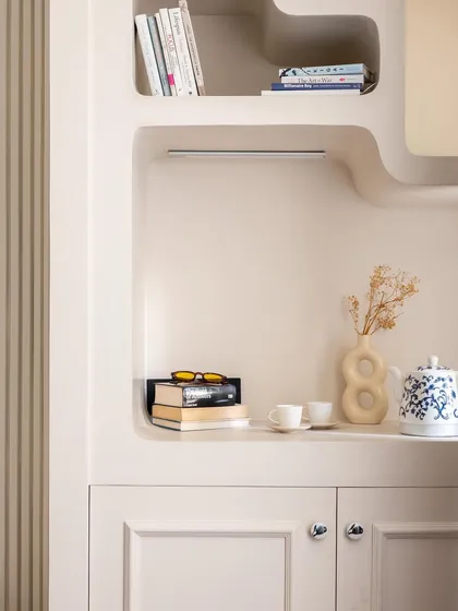 A close-up of the bespoke shelving unit, which serves as a beautiful display for books and personal objects. The soft, curved lines are a recurring motif in my designs.