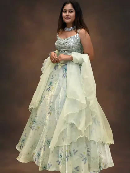 This mint green floral lehenga with a sequined silver choli is fresh, modern, and glamorous. The ruffled dupatta adds a playful and trendy element.