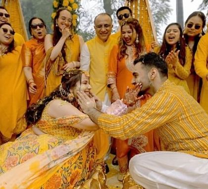 A candid and joyful moment from the Haldi ceremony, with the couple and their loved ones sharing a laugh.