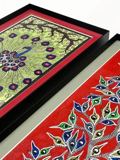 A detail shot of two peacock artworks, showing how different mat colors can be used within the same series to highlight individual pieces while maintaining a cohesive style with matching black frames.