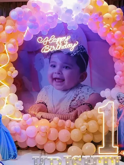 A princess-themed first birthday with a warm, peachy balloon circle and a photo backdrop.