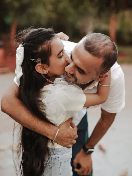 A sweet kiss from daughter to dad. Outdoor sessions allow for so much movement and genuine interaction, resulting in photos filled with authentic love and connection.
