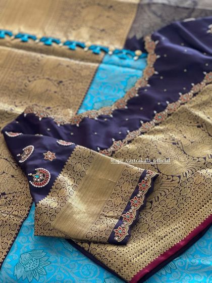 The scalloped neckline of the navy blue blouse is also detailed with fine embroidery.