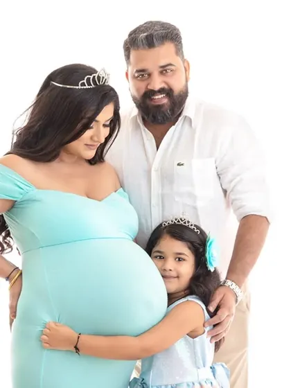A happy family maternity portrait with the daughter hugging her mom's belly. I encourage these natural interactions to capture the love and anticipation of a growing family.