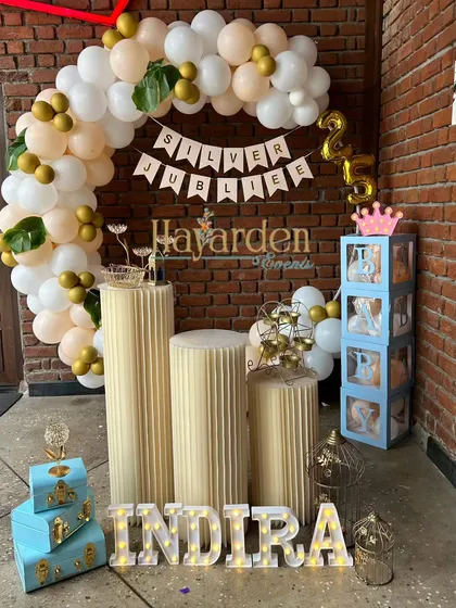 Celebrating a Silver Jubilee 25th anniversary. The decor includes a 'Silver Jubilee' banner, a half-arch of balloons, and marquee letters.