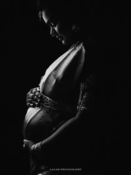 Sometimes, the most powerful stories are told in whispers of light and shadow. This black and white portrait, featuring a mother-to-be in a traditional saree, strips away all but the purest emotion. It is a soulful, timeless tribute to heritage and new life.