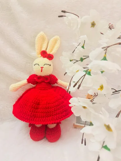 This charming bunny doll is ready for a party in her bright red dress and matching shoes, with a little red bow on her ear.