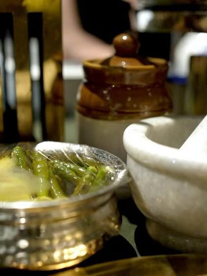We love to mix textures and materials in our setups. Here, you can see ethnic pottery and a marble mortar and pestle used as part of the decor for an authentic Indian food station.