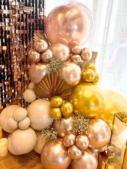 A close-up of the balloon cluster, showing the mix of sizes and finishes that give the garland its organic, high-end feel. The candlelight adds a warm, inviting touch.
