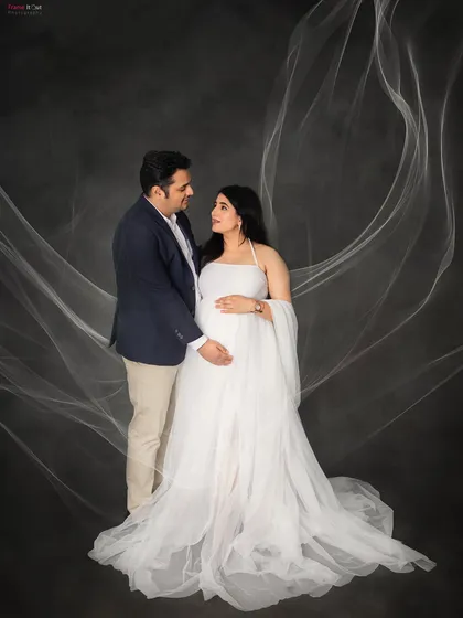A dreamy and romantic portrait of the expecting couple. The delicate, flowing fabric around them adds a touch of magic to this beautiful moment.