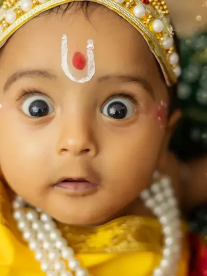 A hilarious and expressive close-up shot that perfectly captures the mischievous spirit of little Krishna.