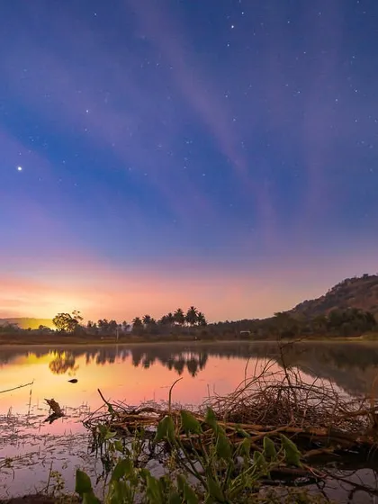 A lucky shot of the Milky Way reflecting in a lake near Bangalore, discovered during an early morning drive. The water lilies in the foreground add a beautiful, earthly element to this celestial scene.