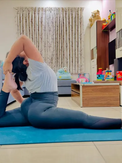 This is an advanced Hanumanasana, or Monkey God Pose, with some extra effort. She is able to touch her head with her feet, a sign of incredible flexibility that comes from consistent and patient practice.