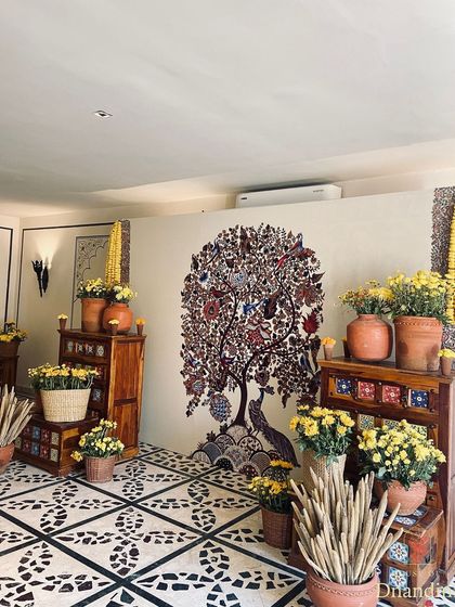 For this Haldi, we brought a piece of the family's home to the decor. This 'Tree of Life' Kalamkari-style painting, a beloved feature in their residence, became the centerpiece of our design, surrounded by marigolds and terracotta.