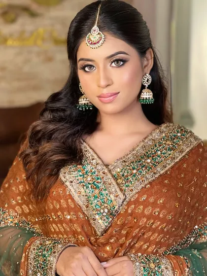 A classic look for a Muslim bride or for a Nikah ceremony. The model wears a beautiful brown and green outfit with traditional jhumkas and a maang tikka.