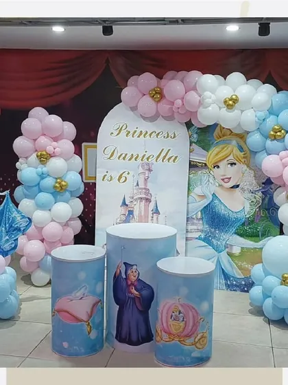 Another Cinderella party setup, this one designed for a 6th birthday with a custom arch backdrop and themed pedestals.