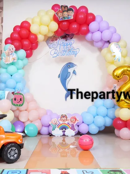 A close-up of the Cocomelon balloon ring, showing the different colors and character stickers.