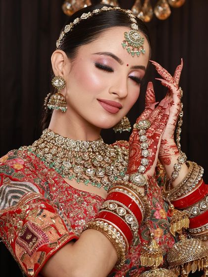 A bride with her eyes closed, as if making a wish, her beautiful mehandi hands held in a prayer-like pose.