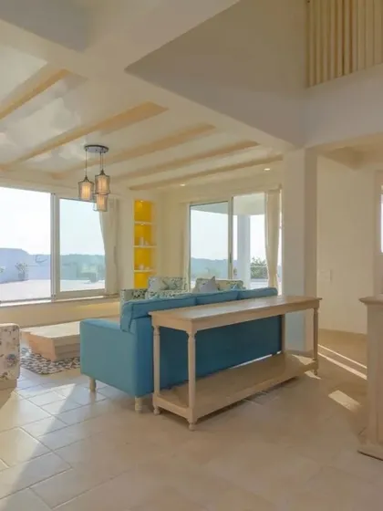The living room in the Goa home is bathed in natural light. The design uses a neutral base with infusions of yellow and blue, while light-toned furniture maintains an airy, relaxed aesthetic perfect for a holiday retreat.