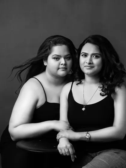 The same two friends in a more casual, black and white portrait. This image strips back the glamour to show the simple, authentic connection and trust between them.