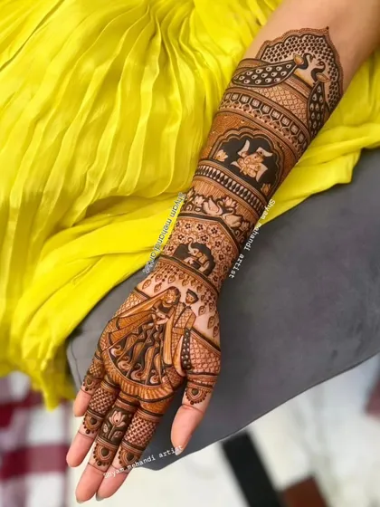 A full-arm design with a couple portrait on the palm and traditional elephant and peacock motifs on the arm.