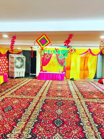 A view of the hall prepared for a Janmashtami celebration. The space is decorated with colorful fabrics and traditional elements, creating a vibrant yet spiritual setting.