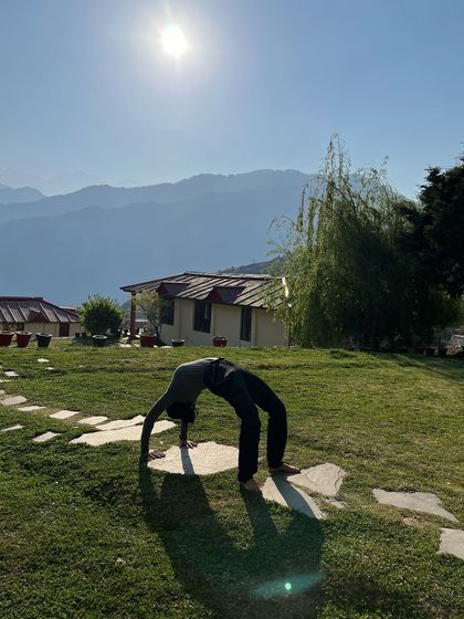Practicing Chakrasana (Wheel Pose) in the morning sun in the Himalayas. A few minutes of yoga each morning teaches the body to stretch and adapt, so that when life challenges us, we bend instead of break.