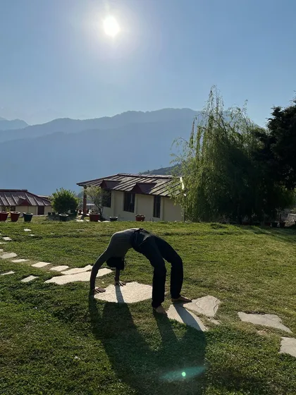 Practicing Chakrasana (Wheel Pose) in the morning sun in the Himalayas. A few minutes of yoga each morning teaches the body to stretch and adapt, so that when life challenges us, we bend instead of break.