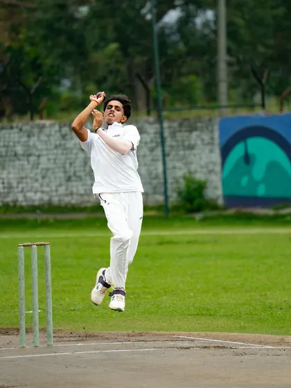 A spinner in mid-air, putting everything into the delivery. We teach our bowlers to use their whole body to generate turn and flight, making them a threat on any surface.