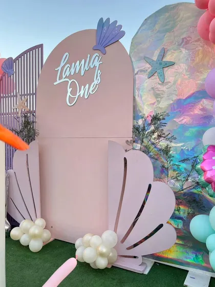 A detailed view of the mermaid party backdrop, featuring an iridescent panel that mimics shimmering water.