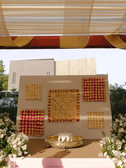 A modern and artistic Haldi setup. The backdrop features geometric patterns made of flowers, showing how I can blend traditional rituals with contemporary design aesthetics.