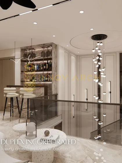 For this duplex, I incorporated a luxurious home bar counter. The design features backlit shelving for bottles, stylish bar stools, and a stunning cascading chandelier over the staircase, creating a perfect spot for entertaining.