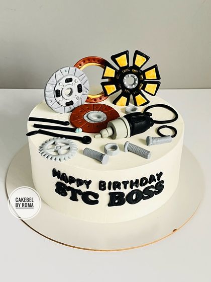 A client sent me an AI-generated image of a cake with car parts, and I brought it to life. This cake, for the "STC Boss," features handcrafted fondant gears, clutches, and bolts.