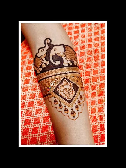 A close-up of the arm, featuring a beautiful elephant and a portrait of Lord Ganesha, perfect for starting the wedding festivities with blessings.