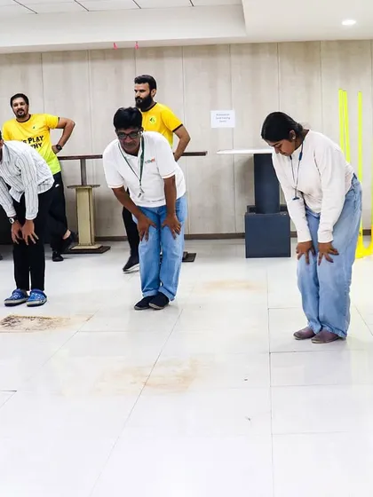 Participants engage in stretching exercises during a corporate fitness session. We emphasize proper form and safe movements to ensure a beneficial experience for all employees.