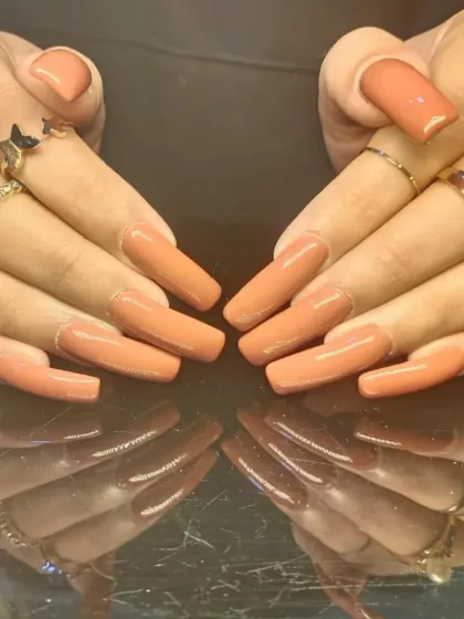 A bold yet neutral set of extra-long, square-shaped nails in a solid caramel-nude color.