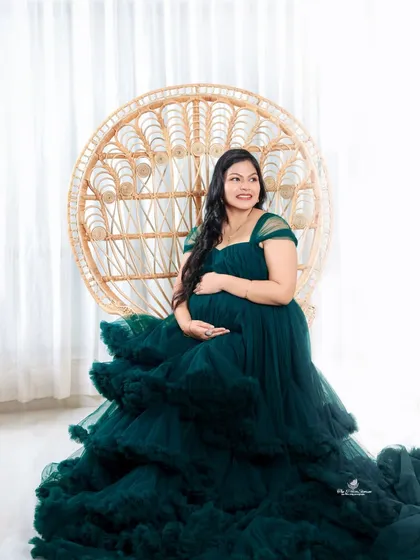 We love capturing the pure joy and radiance of pregnancy. This solo portrait, featuring a stunning green gown and a bright, airy setup with a boho peacock chair, is all about celebrating the beautiful mom-to-be.