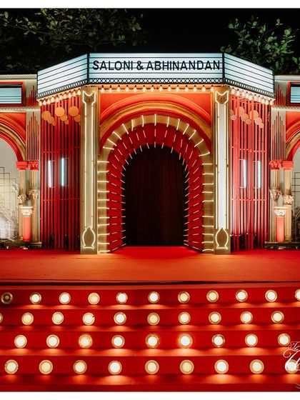 For a Bollywood-themed Sangeet, I created this grand cinema-style entrance. The red carpet, marquee sign with the couple's names, and stage lights set the tone for a night of cinematic celebration.