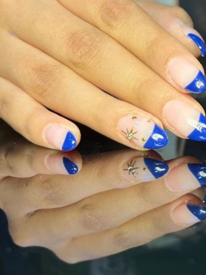 A side view of the geometric blue French manicure, showing the clean lines and starry accents.