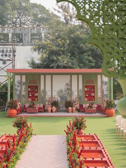 A wide shot showing the relationship between the aisle, guest seating, and the lounge area. The entire space is designed as a cohesive Mughal-inspired garden.