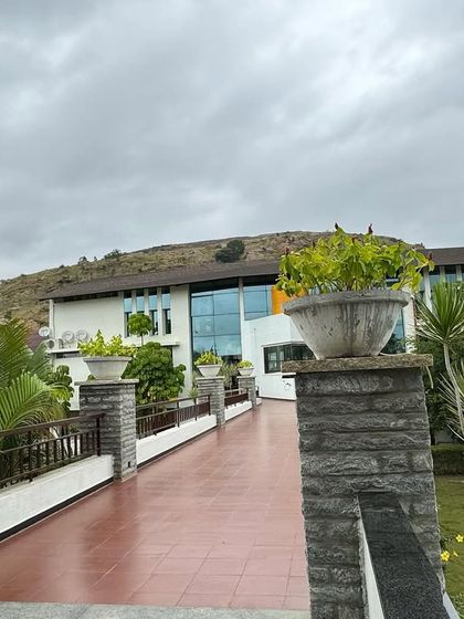 The walkway leading to our main hall, lined with stone pillars and planters. This entrance is designed to be a transition from the outside world into a space of tranquility and healing.