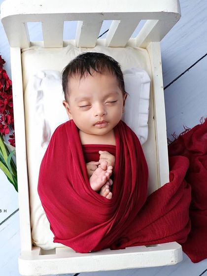 A top-down view of the baby in the bed with red and white flowers.
