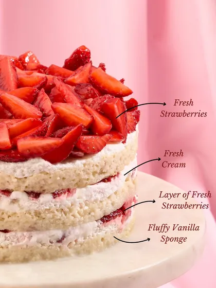 A closer look at the layers of our Strawberry Bliss Cake. You can see the fluffy vanilla sponge, fresh cream, and layers of sliced strawberries that make it so popular.