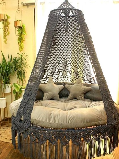 Our dual seater swing in a dark grey, featuring star-shaped pillows. The intricate floral pattern on the canopy adds a touch of elegance to the modern color.