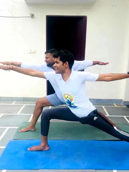 Demonstrating the correct alignment for Warrior II pose during a session for SR Goel & Associates. Proper form is key to preventing injury and getting results.