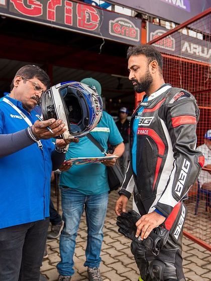 Safety first. A rider's helmet getting checked during the scrutiny process at the Bengaluru EV Festival. We ensure all gear meets safety standards.
