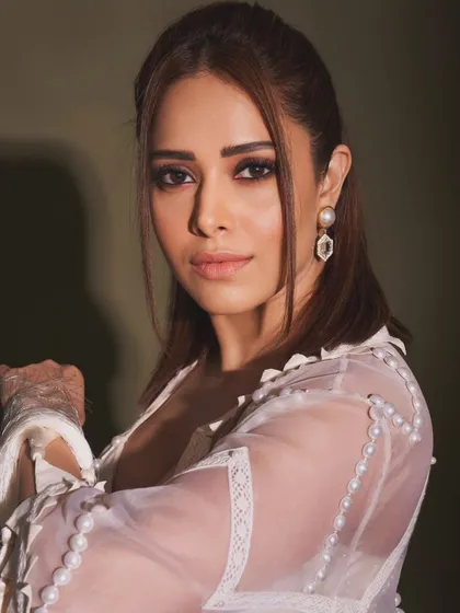 Pearls and tassels make this white indo-western outfit on Nushrratt Bharuccha truly special. The fringed jacket adds a playful, bohemian touch to the elegant sharara set.