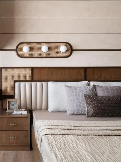 The parent's bedroom was designed to have a vintage feel with zen wood vibes. The headboard combines wood, cane, and upholstery, set against a wall with horizontal bands of texture for a calm, nostalgic atmosphere.